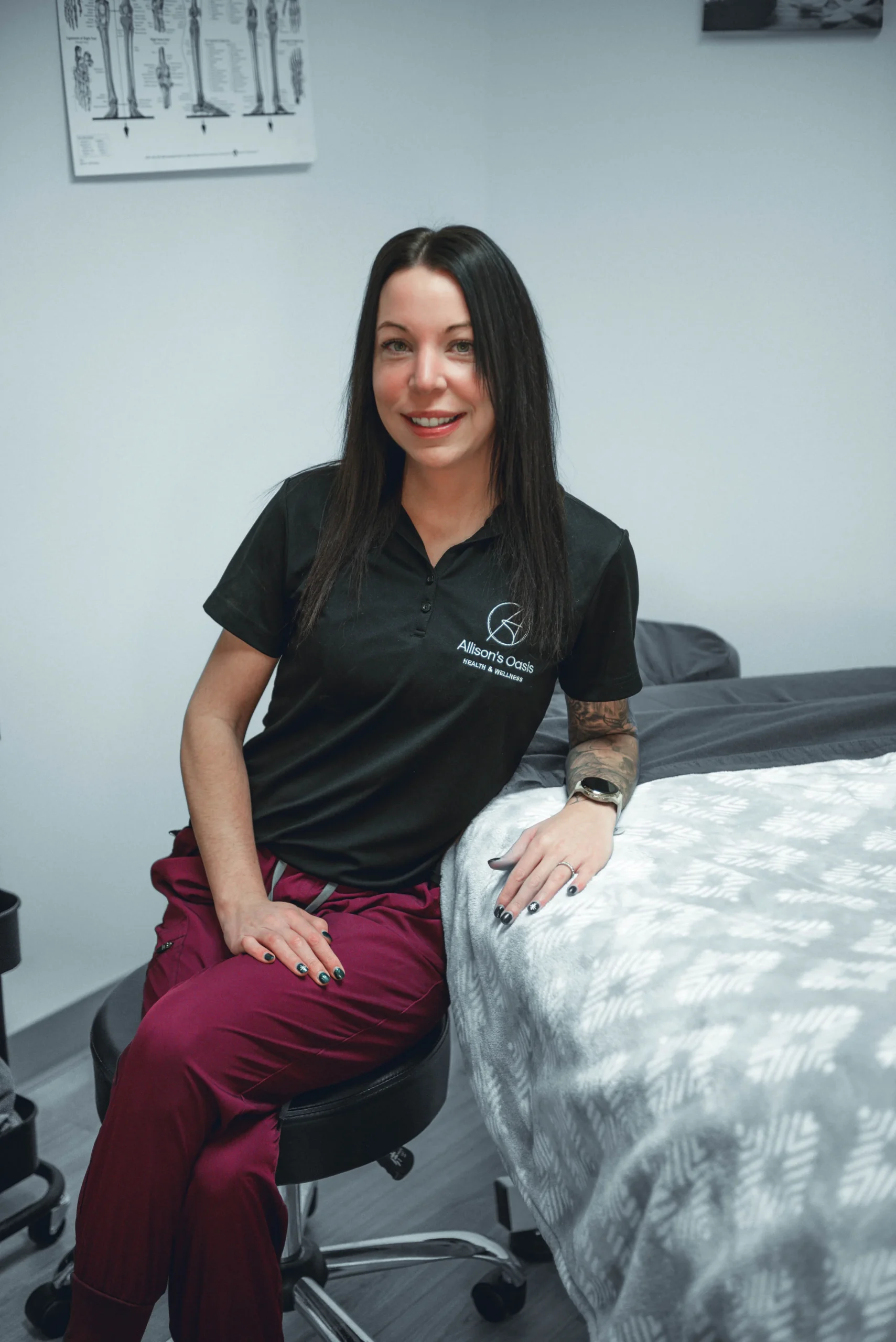 Allison's Oasis - Professional Headshot of Allison leaning against massage table.